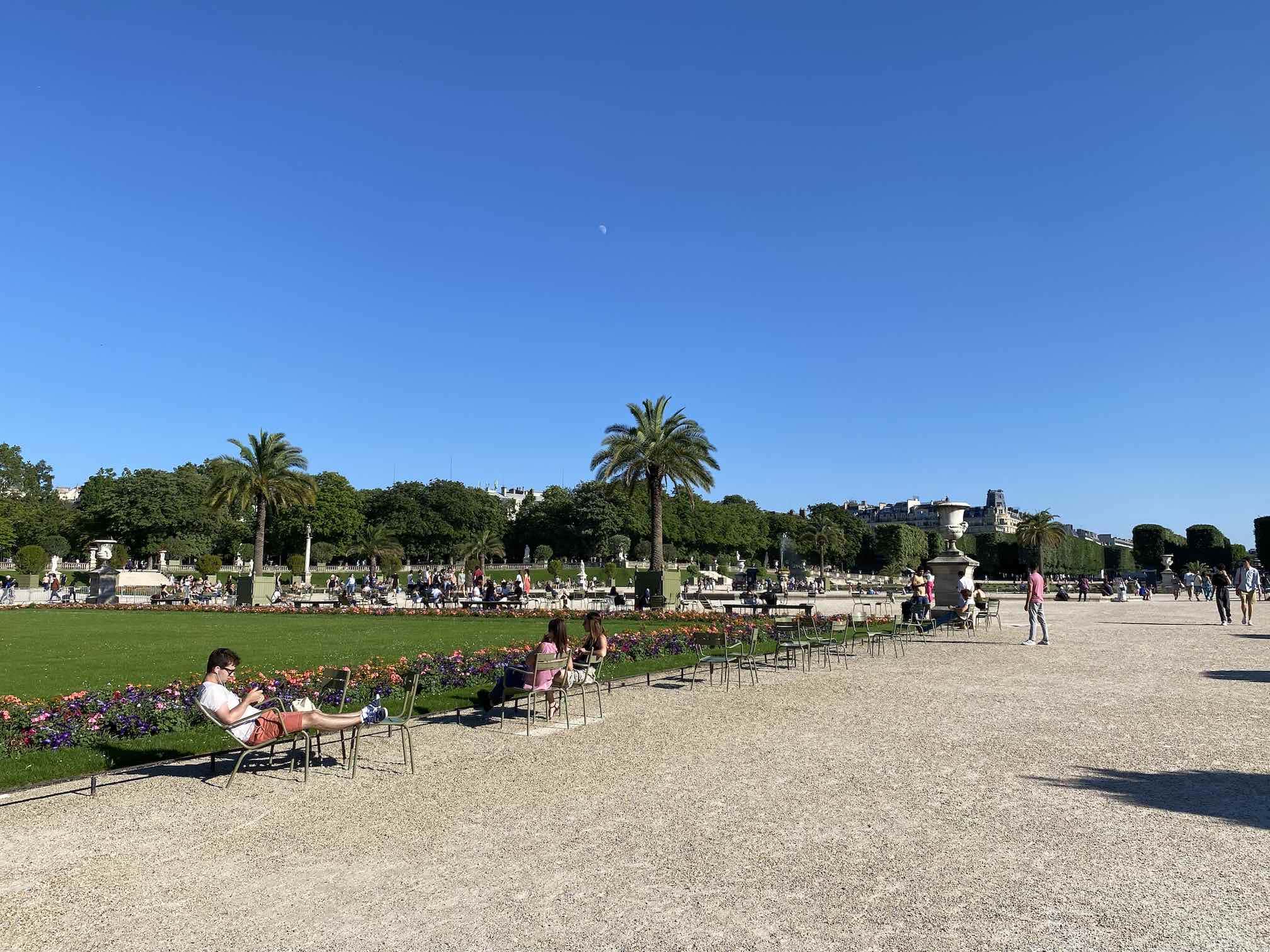 Jardin du Luxembourg, Paris, Parks in Paris, Blick auf den Park mit Wiese und Stühlen auf denen Menschen das Wetter genießen