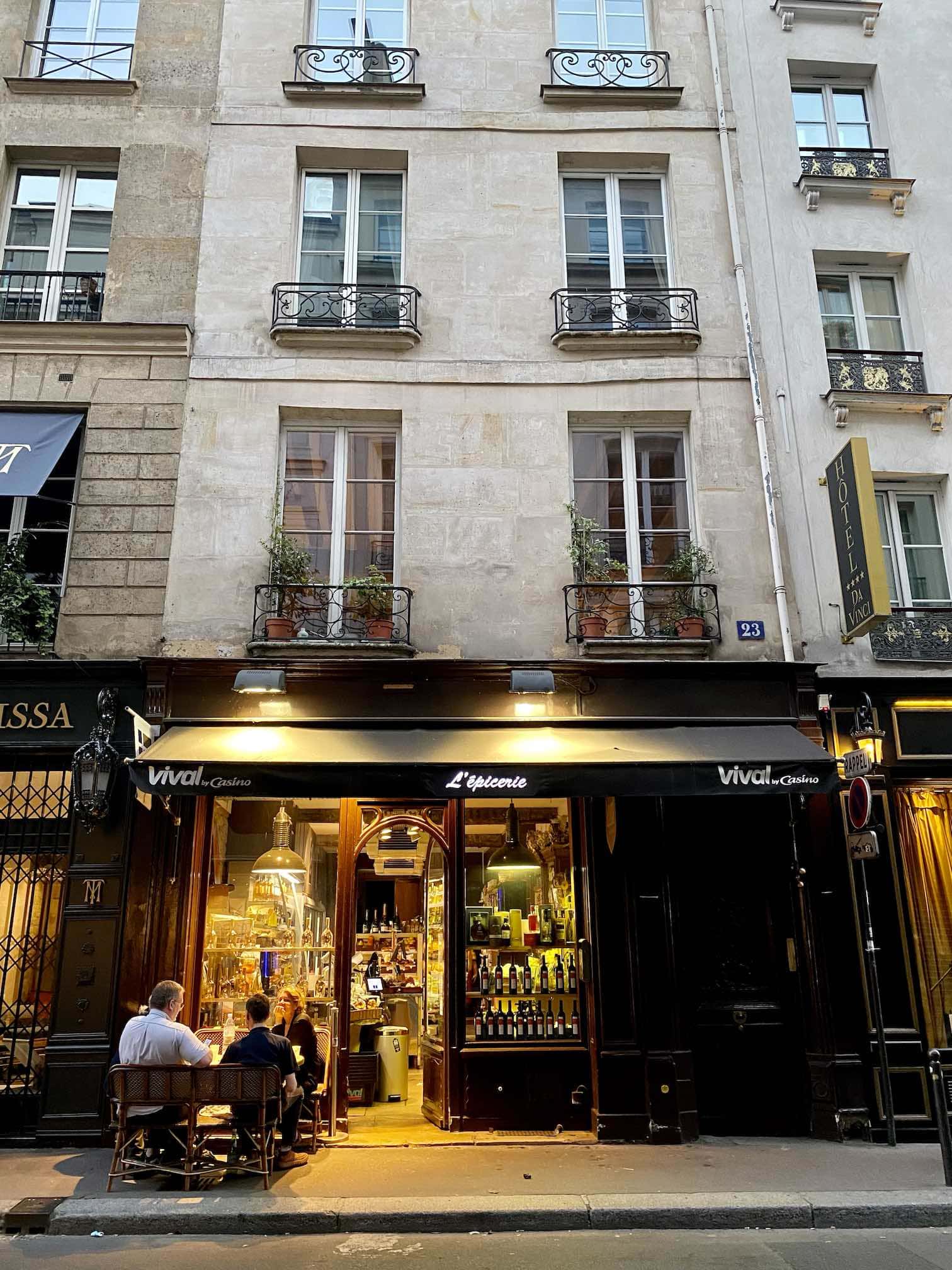 lauer Sommerabend in Paris, Restaurant, vor dem Menschen ein Glas Wein geniessen