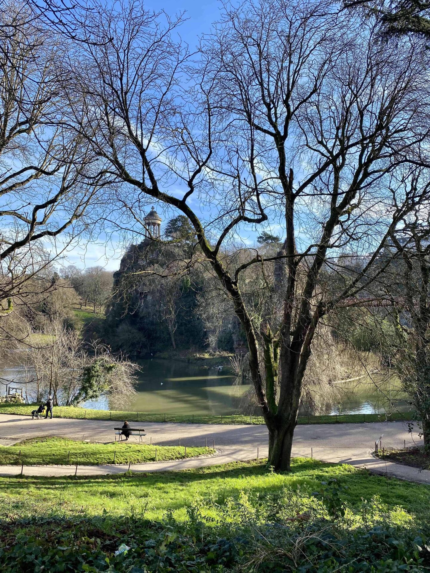 Park Buttes Chaumont in Paris, Aussicht auf den Felsvorsprung mit griechisch inspiriertem Tempel und grünen Wiesen