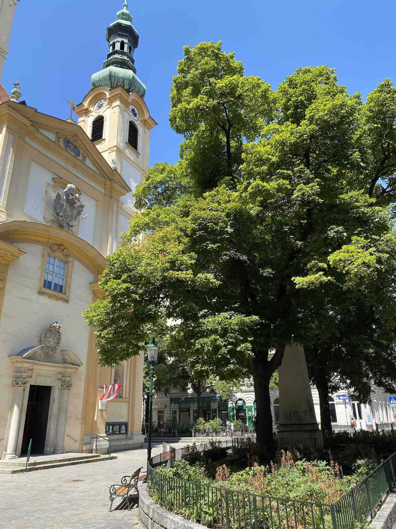 Servitenviertel Wien, Kirche mit Vorplatz, Baum und Bepflanzung, sonniger Tag, blauer Himmel